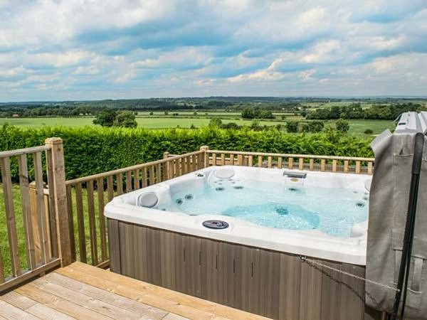 veranda with hot tub and a fantastic farm view
